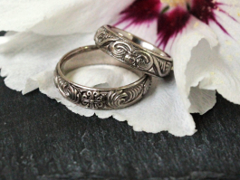 No. 003 Trauringe mit romanischen Ornamenten: 
In Weißgold gefertigt auf einer weißen Hibiskus Blüte sitzend.