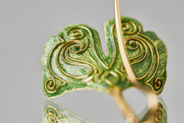 Ginkgo Blätter Detailansicht: Rückseite eines liegenden Blattes. Die in Gelbgold gegossenen Blätter strahlen mit grün-transparentem Feueremaille. Deutlich zusehen sind die in Gelbgold geformten Elemente.